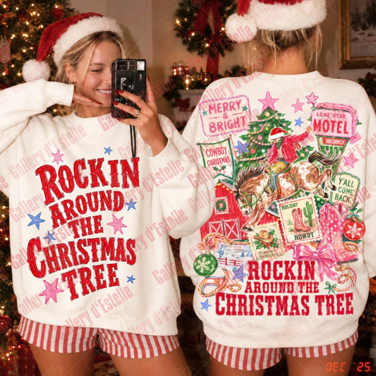 A woman modeling a Christmas-themed crewneck sweatshirt in a holiday home setting, showing both the front and back views. The sweatshirt is white with red and pink text and graphics reading 'ROCKIN' AROUND THE CHRISTMAS TREE' on the front and a busy collage of Christmas motifs on the back.