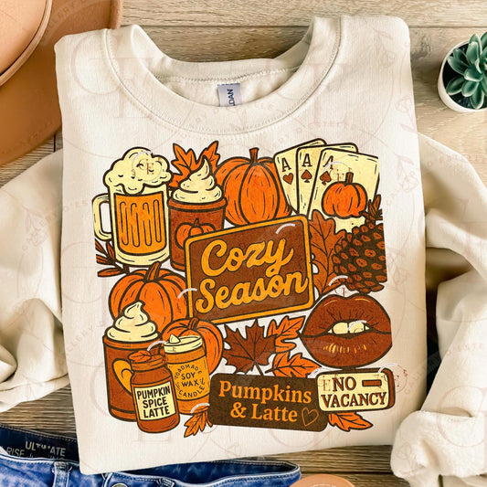 White sweatshirt with autumn-themed graphics and text on a wooden surface.