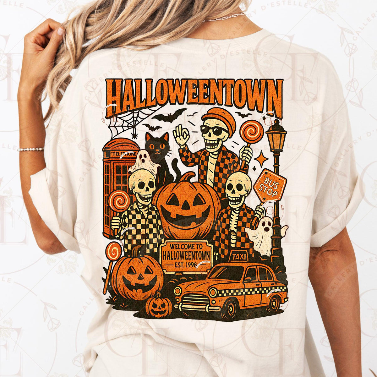 White t-shirt with 'Halloweentown' graphic design featuring skeletons, pumpkins, and a taxi.
