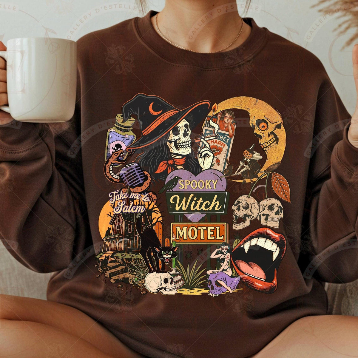 Person wearing a brown sweatshirt with a Halloween-themed design, holding a mug.