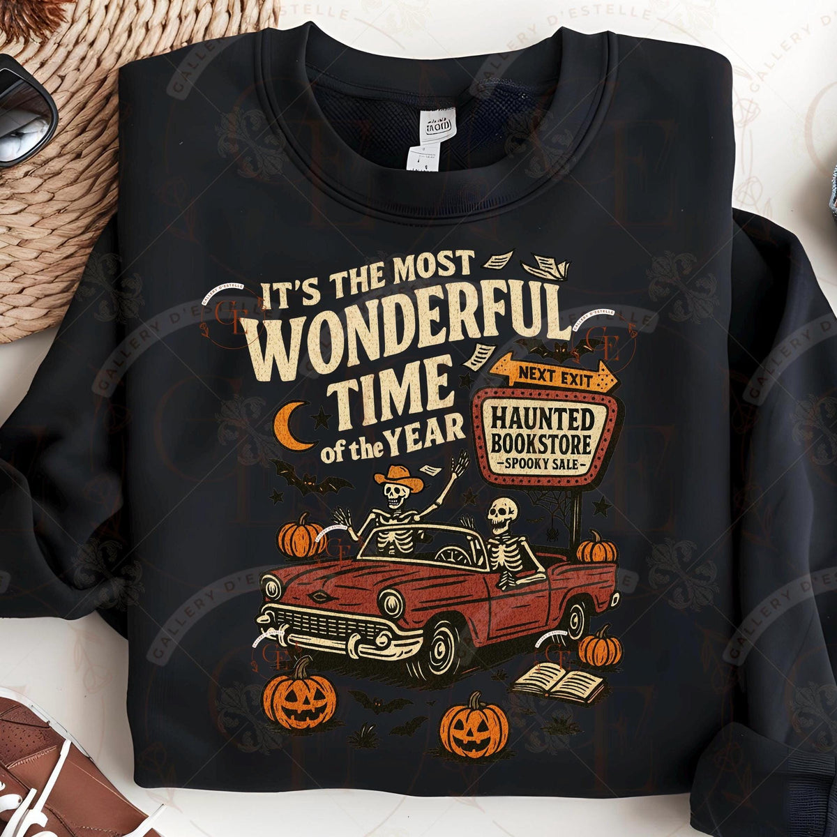 Black sweatshirt with Halloween-themed design featuring skeletons in a car and pumpkins.
