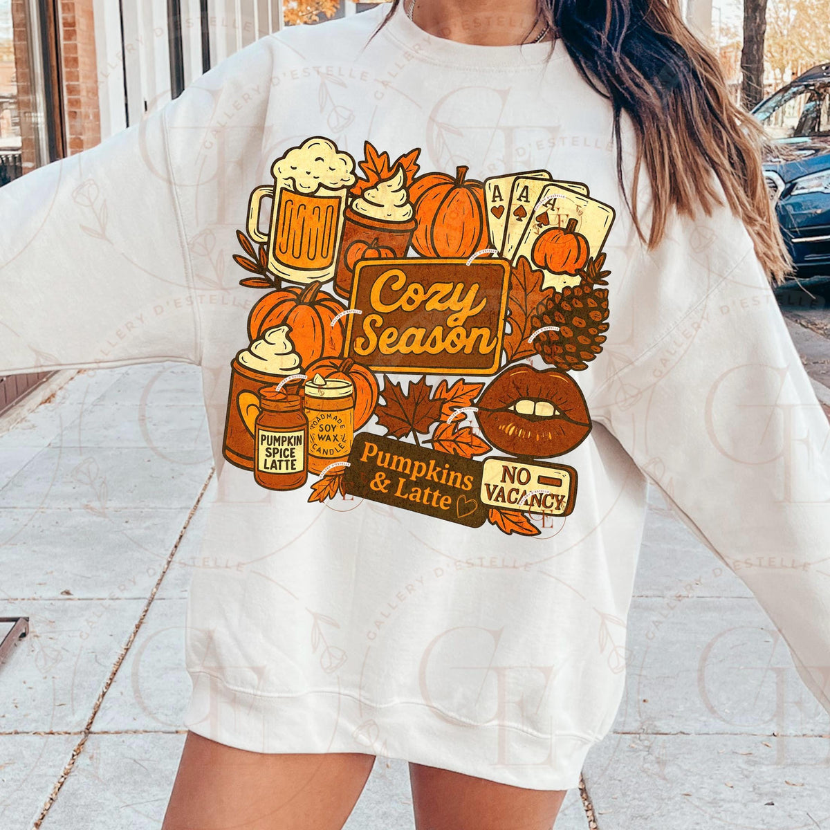 Person wearing a white sweatshirt with autumn-themed graphics and text.