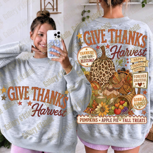 A woman modeling a light gray sweatshirt from both the front and back. The front shows the text 'GIVE THANKS Harvest' in orange and brown, while the back features a large autumn-themed graphic with a turkey, pumpkins, flowers, and the phrases 'GIVE THANKS Harvest', 'HAPPY THANKS GIVING', 'FOREVER GRATEFUL', and 'GOBBLE GOBBLE'.