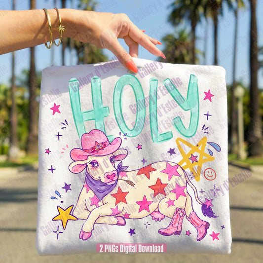 Funny t-shirt  held by a hand with a cowgirl-themed design featuring a cow in a pink hat and boots, surrounded by stars and the word 'HOLY'.