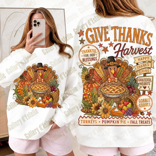 A white long-sleeve sweatshirt with a large colorful Thanksgiving harvest graphic, shown on a model from both the front and back. The graphic features a turkey, pumpkin pie, autumn leaves, and seasonal text like 'Give Thanks Harvest' and 'Thankful for Our Blessings'.