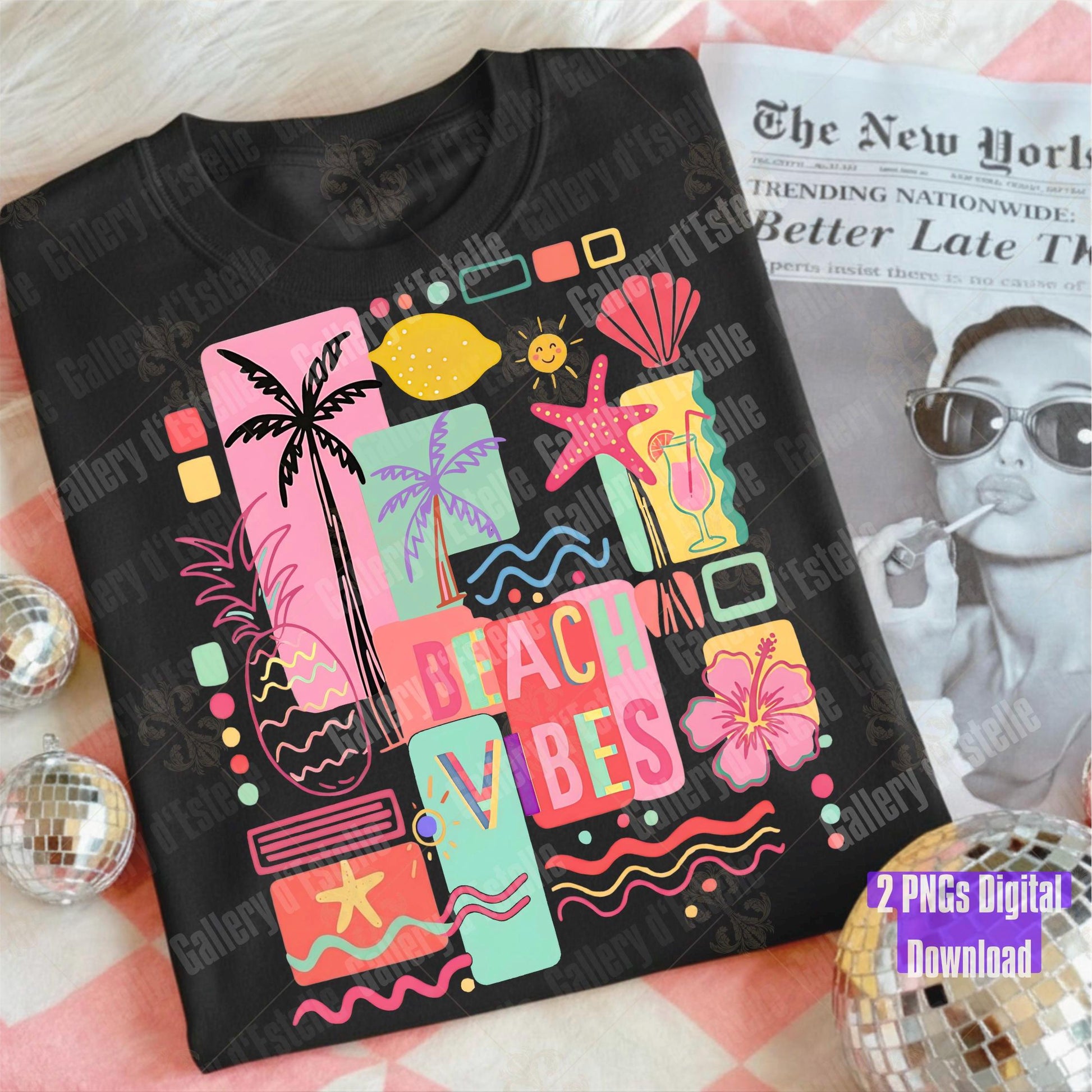 Black t-shirt with a colorful summer collage design and the phrase'Beach Vibes' on a pink surface with a magazine underneath.