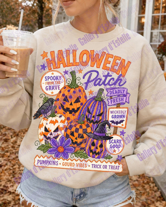 A woman wearing a cream-colored sweatshirt with a colorful Halloween graphic that reads 'Halloween Patch' and features jack-o'-lanterns, pumpkins, a witch, and a raven, holding an iced coffee outdoors.