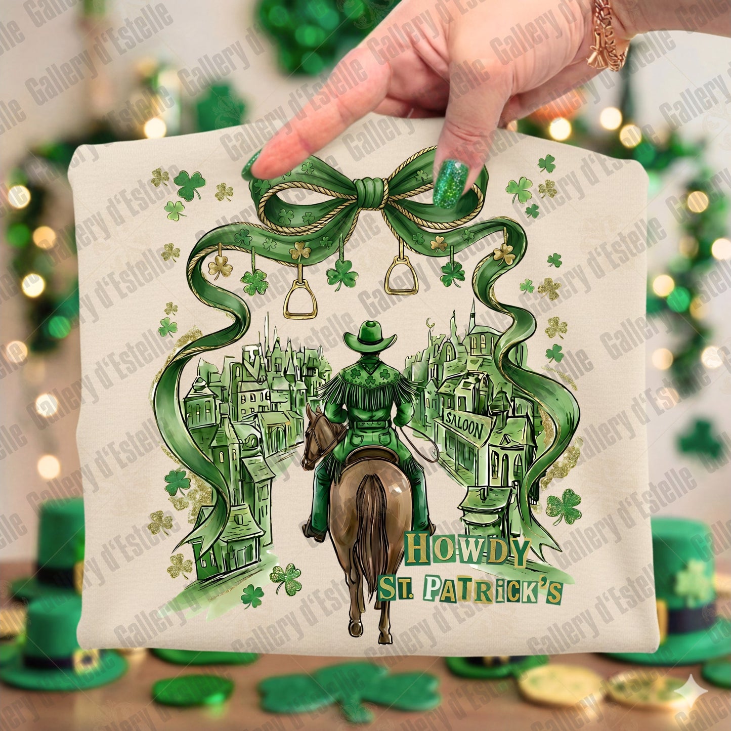 Beige folded T-shirt with a cowboy and saloon design, featuring shamrock patterns and 'Howdy St. Patrick's' text, held by a hand.