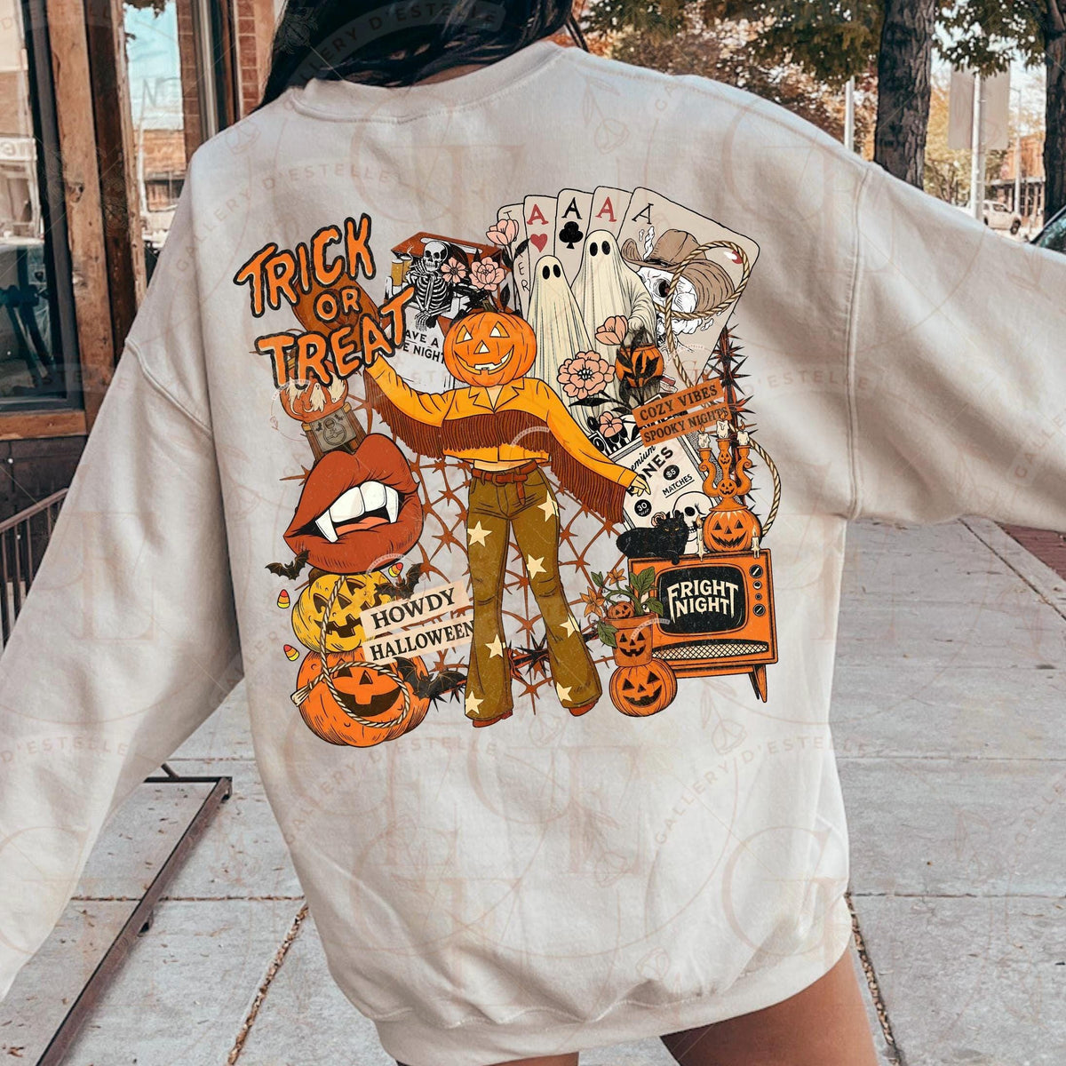 Person wearing a beige sweatshirt with Halloween-themed graphics on the back.