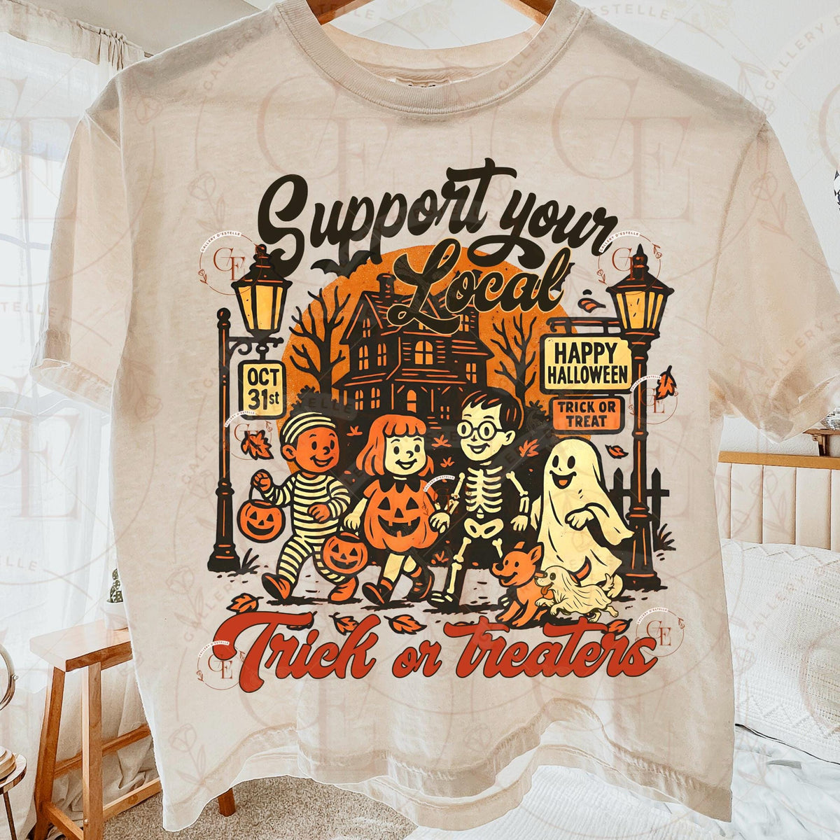 T-shirt with Halloween-themed design featuring trick-or-treaters and text.