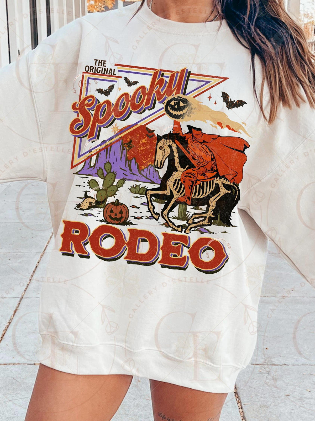 Person wearing a white t-shirt with a 'Spookly Rodeo' graphic design.