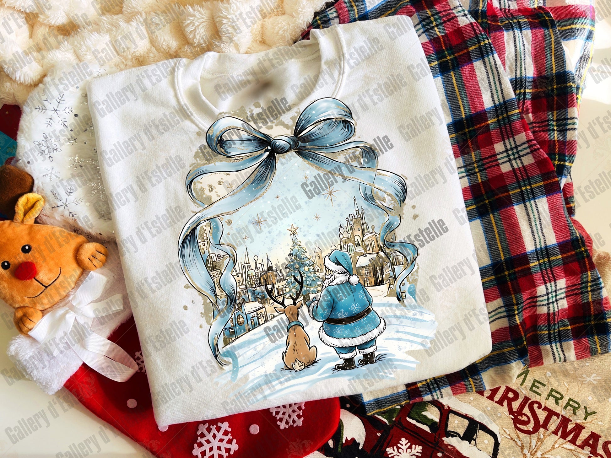 White shirt with Christmas-themed design featuring Santa Claus and reindeer, placed on a plaid fabric background.