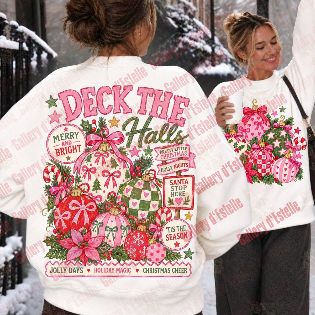 A white crewneck sweatshirt with a large pink and green Christmas graphic on the back, shown on a model in a snowy outdoor setting. The graphic features the text 'DECK THE HALLS' and festive ornaments.