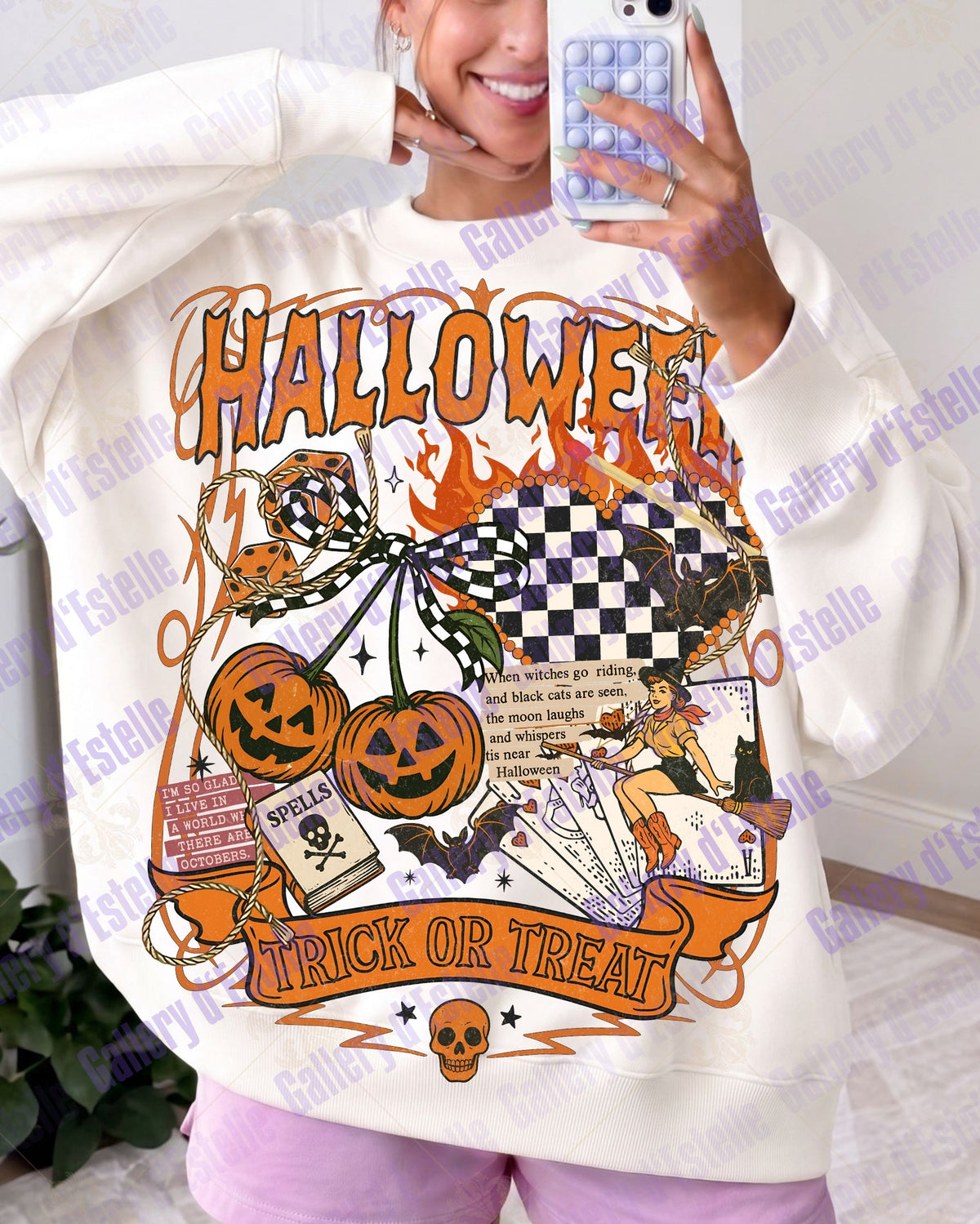 A person taking a mirror selfie wearing a cream-colored sweatshirt with a large orange and black Halloween graphic that reads 'HALLOWEEN' and 'TRICK OR TREAT'.