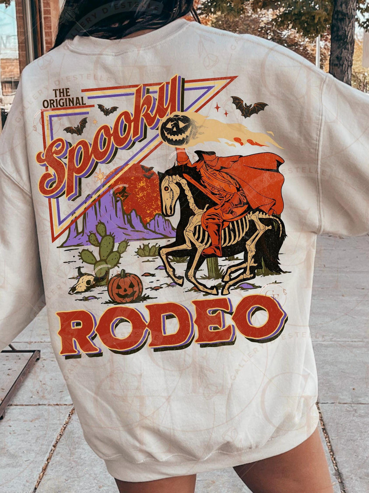 Beige sweatshirt with Halloween-themed design featuring a skeleton on a horse and text.
