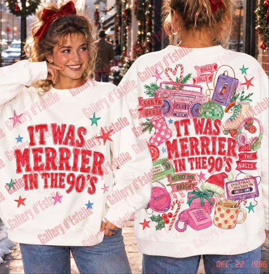 A white crewneck sweatshirt shown from both front and back on a model in an outdoor holiday street setting. The front features the red text 'IT WAS MERRIER IN THE 90's' with small multicolored stars.