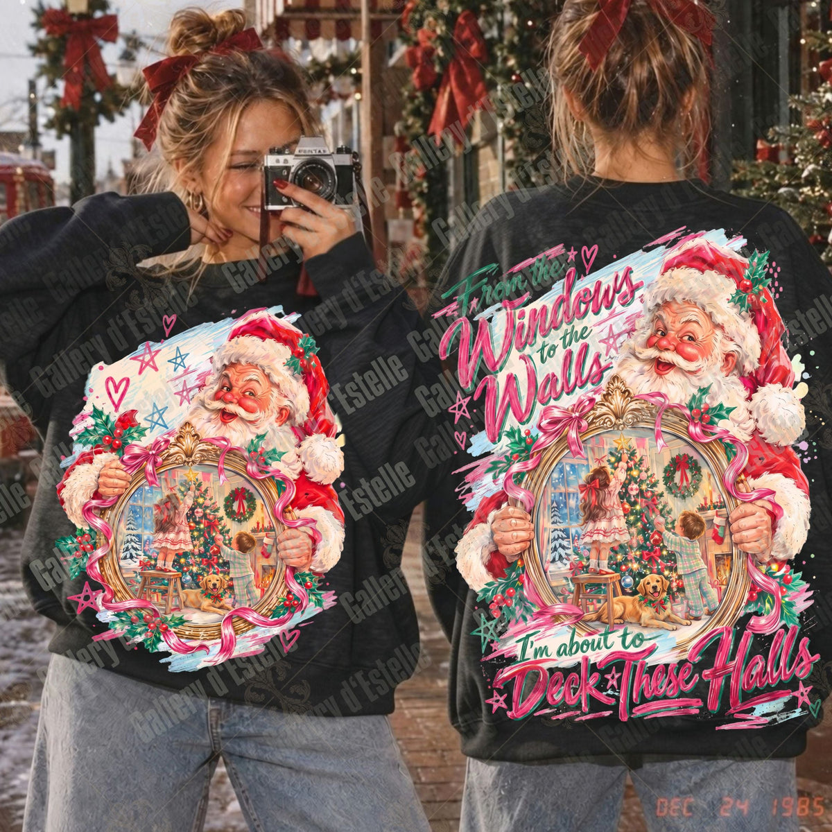 A person shown from the back wearing a black graphic sweatshirt with a large colorful Christmas Santa design, alongside a front view of the matching graphic on the back. The setting appears to be an outdoor holiday storefront with garlands and decorations.