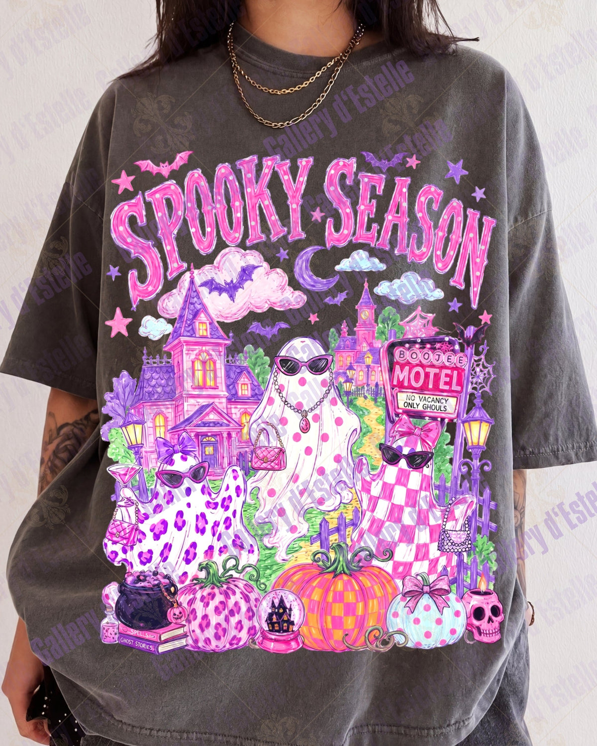 A person wearing an oversized faded charcoal gray graphic t-shirt with a vibrant pink and purple 'Spooky Season' Halloween illustration featuring three ghosts, haunted house, pumpkins, and a motel sign.