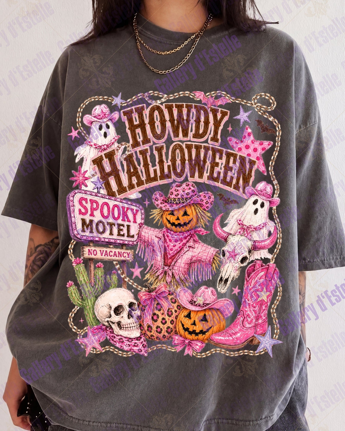A person wearing an oversized faded charcoal gray graphic t-shirt with a colorful 'Howdy Halloween Spooky Motel' print featuring ghosts, pumpkins, and skulls.
