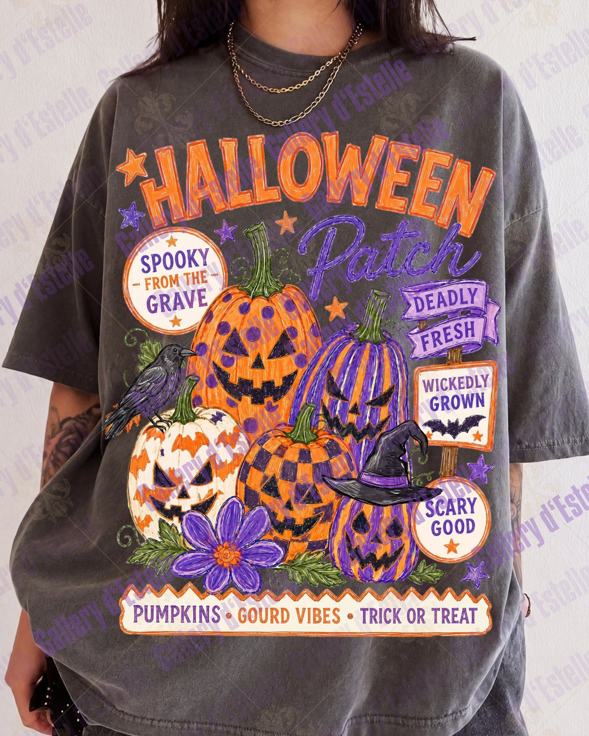 A person wearing a faded charcoal gray graphic T-shirt with a large Halloween-themed print featuring pumpkins, flowers, a raven, and text including 'HALLOWEEN Patch'