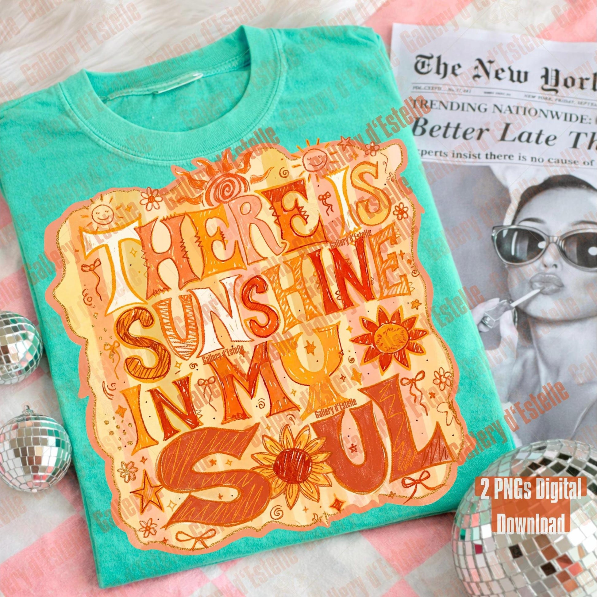 Turquoise t-shirt with decorative text and graphics on a surface with a magazine and disco balls.
