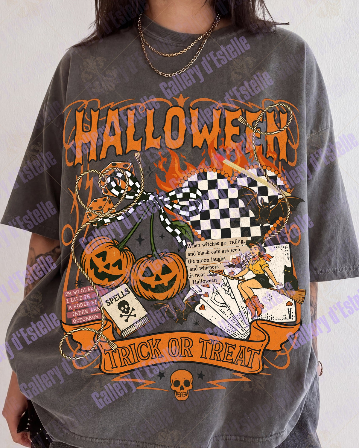 A person wearing an oversized faded charcoal gray graphic t-shirt with a Halloween theme, featuring orange 'HALLOWEEN' text, jack-o'-lanterns, a witch, and playing cards, set against a light gray background.