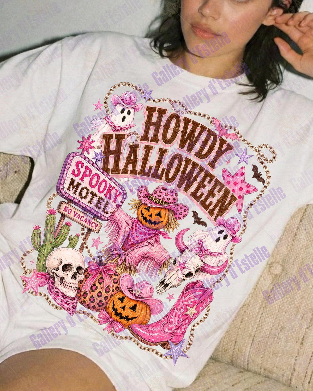 A woman reclining on a beige couch wearing a white graphic T-shirt with a colorful Halloween-themed print reading 'HOWDY HALLOWEEN' and 'SPOOKY MOTEL.'.