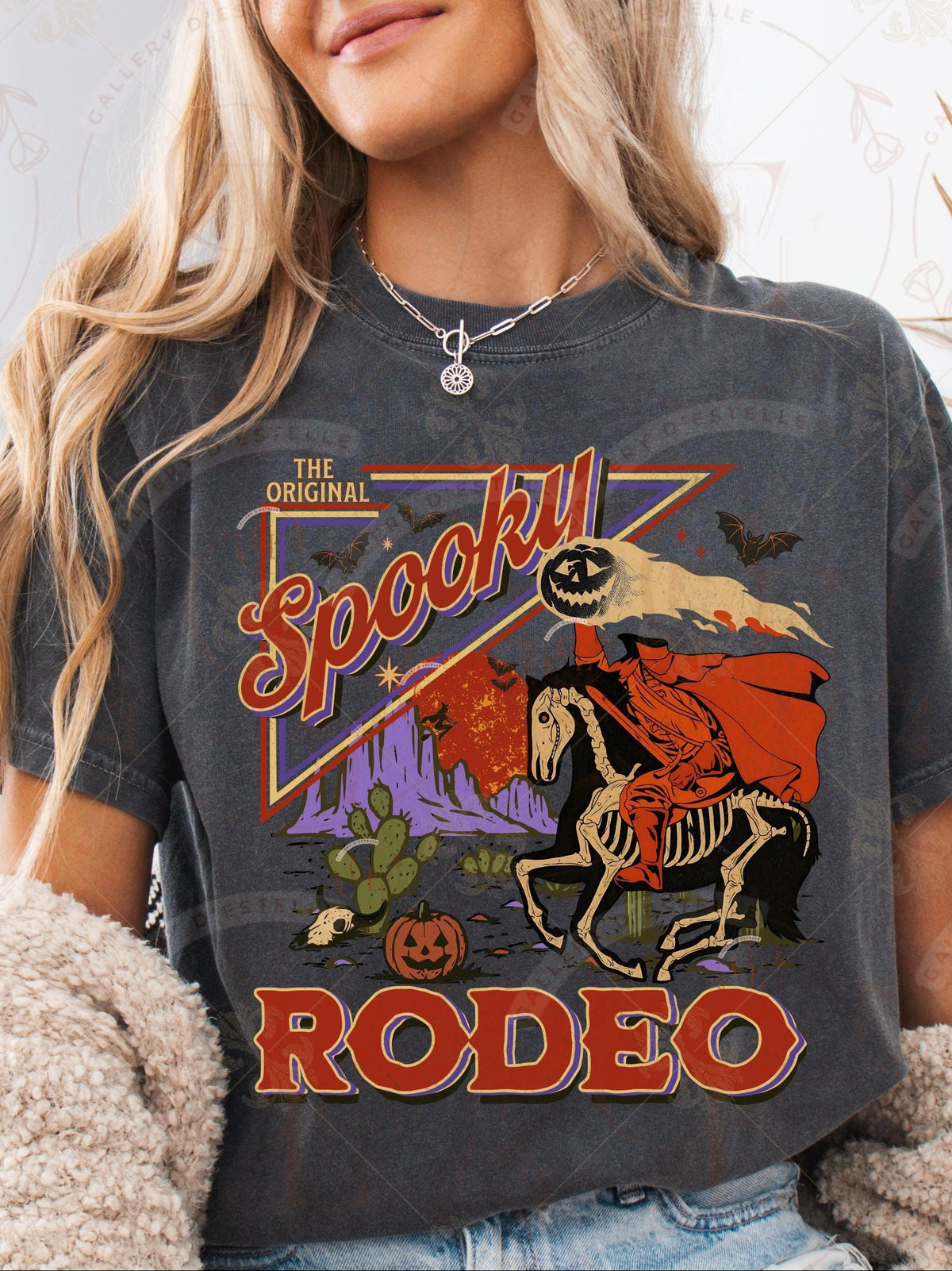 Person wearing a t-shirt with 'Spooky Rodeo' graphic design featuring a skeleton rider on a horse.
