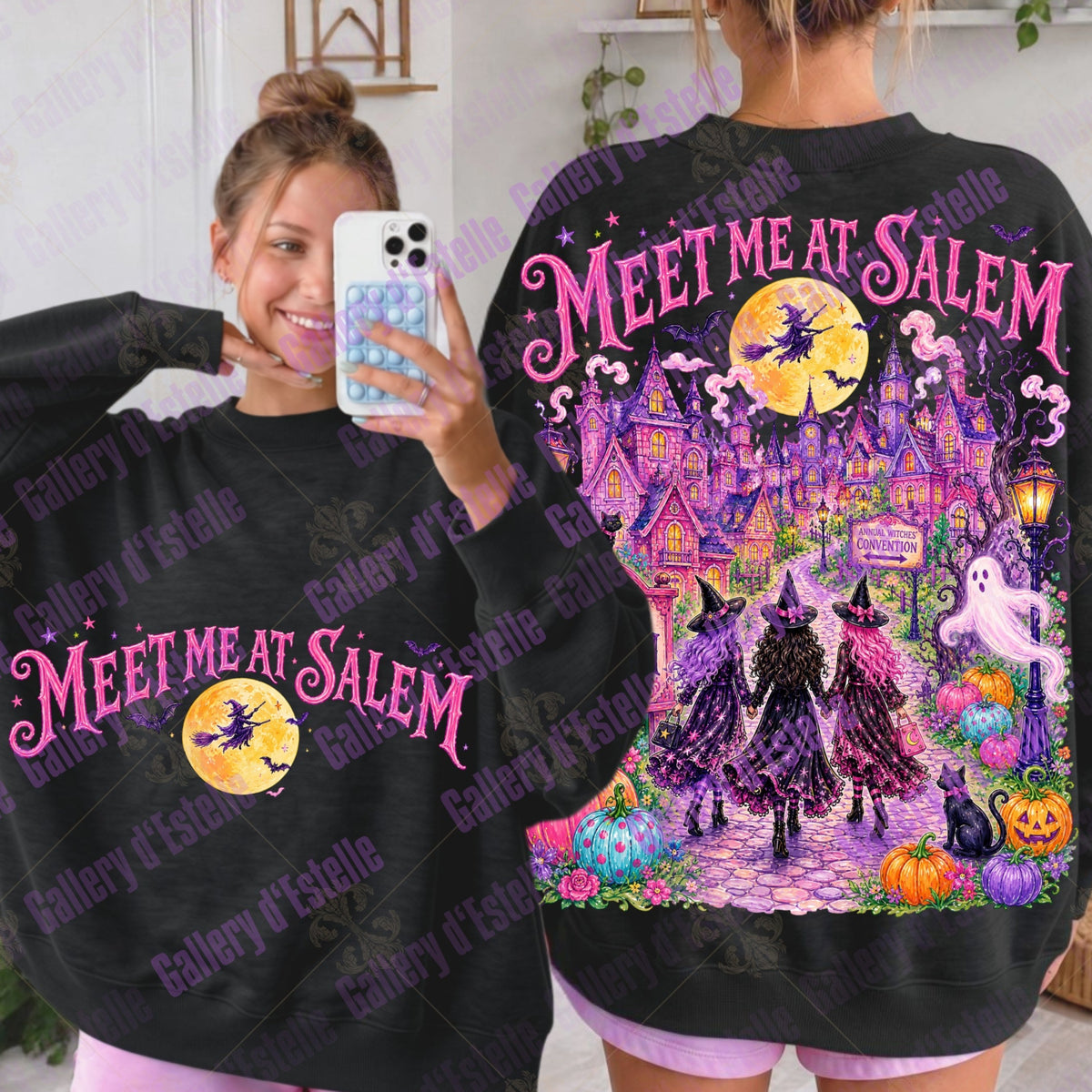 A woman modeling a black sweatshirt with a large Halloween-themed graphic that reads 'MEET ME AT SALEM.' The front view shows pink script text and a yellow moon with a witch silhouette; the back view shows a detailed haunted-house scene with purple, pink, orange, and yellow elements.