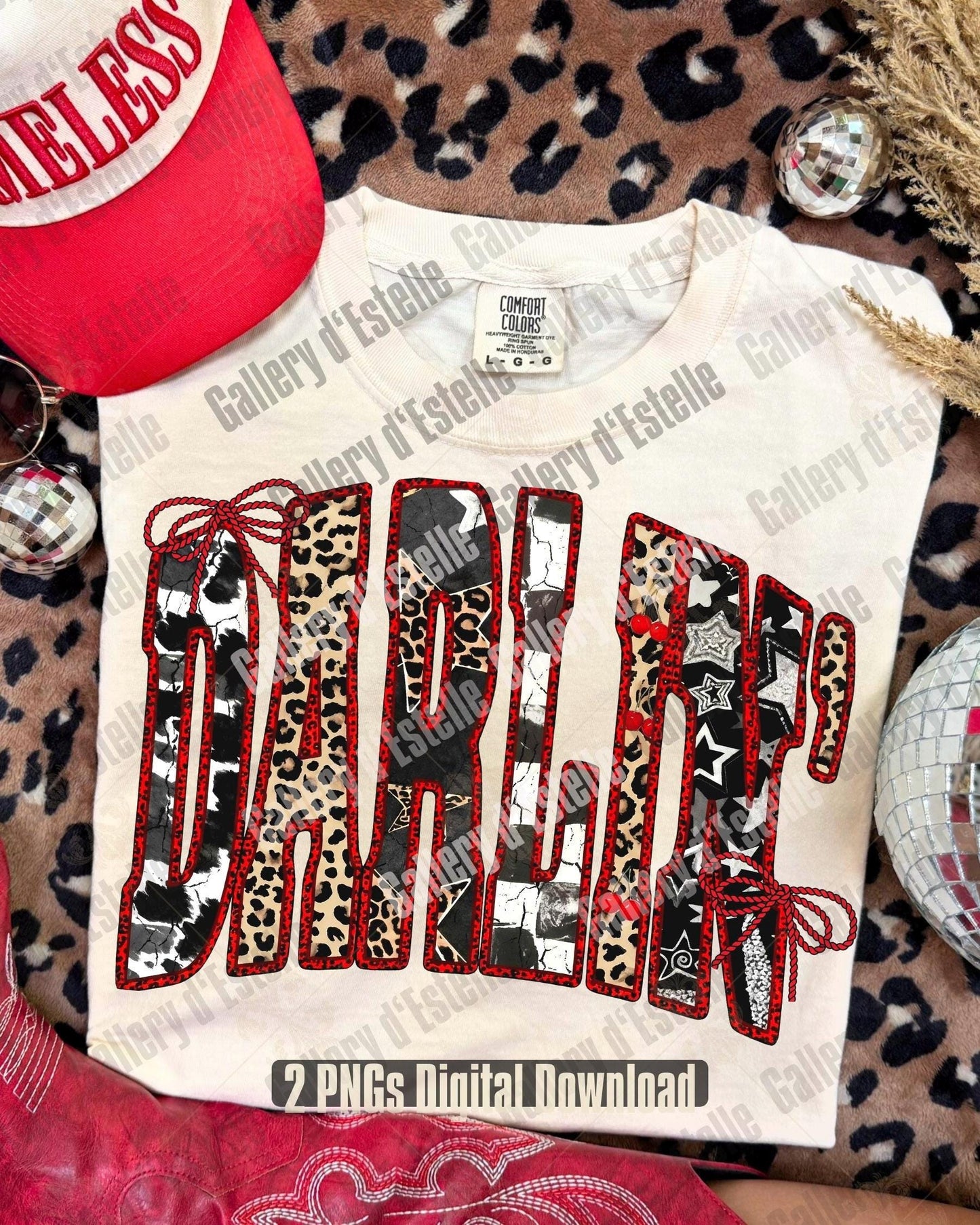 Beige folded t-shirt with 'DARLING' in colorful patterns and leopard patterns around laying on the floor.