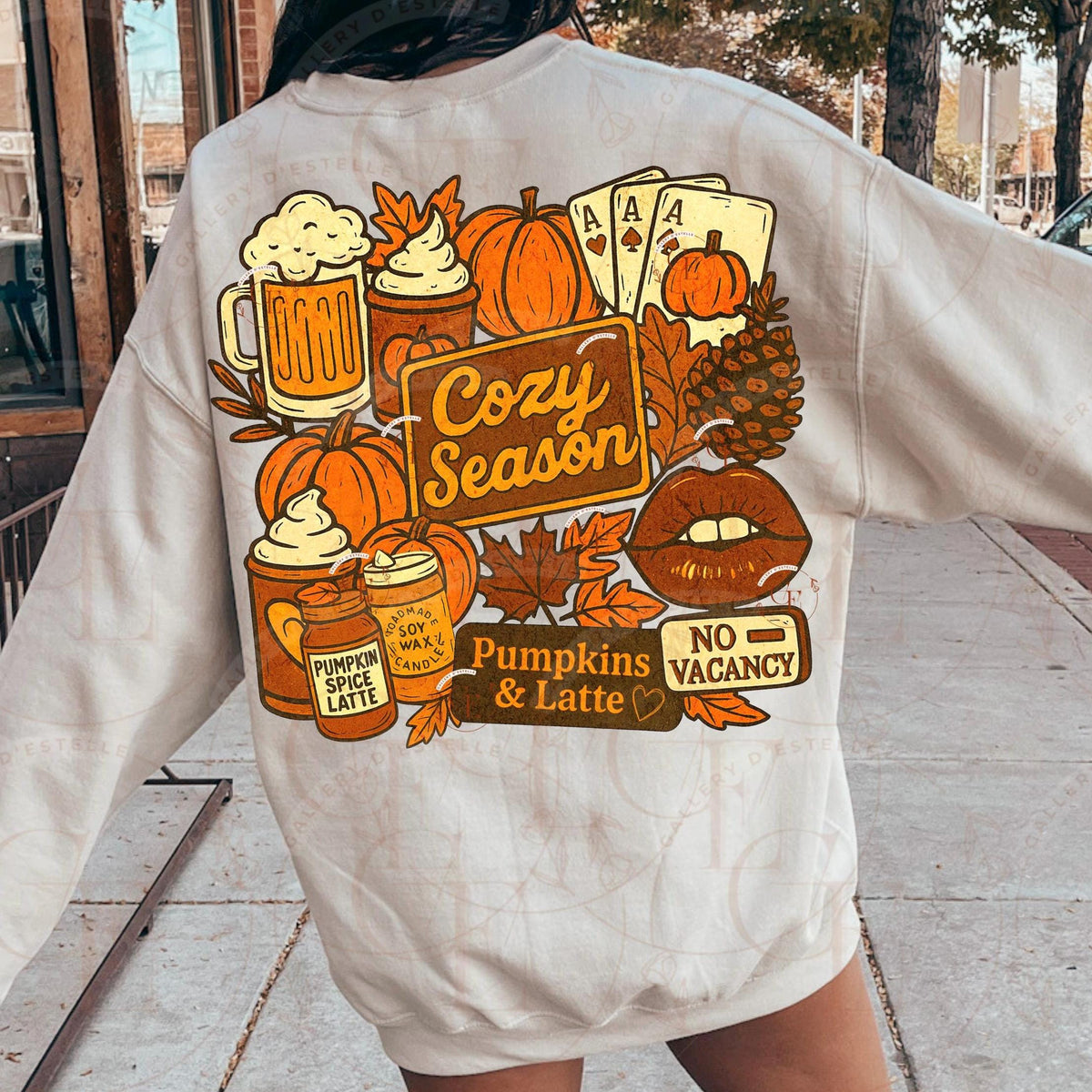 Person wearing a beige sweatshirt with autumn-themed graphics on the back.