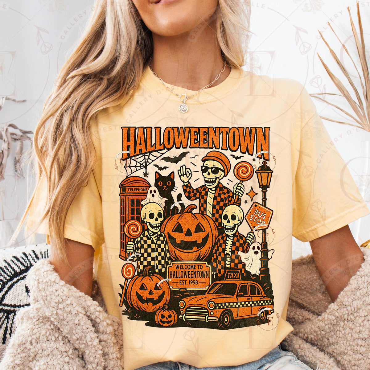 Person wearing a yellow t-shirt with 'Halloweentown' graphic design.