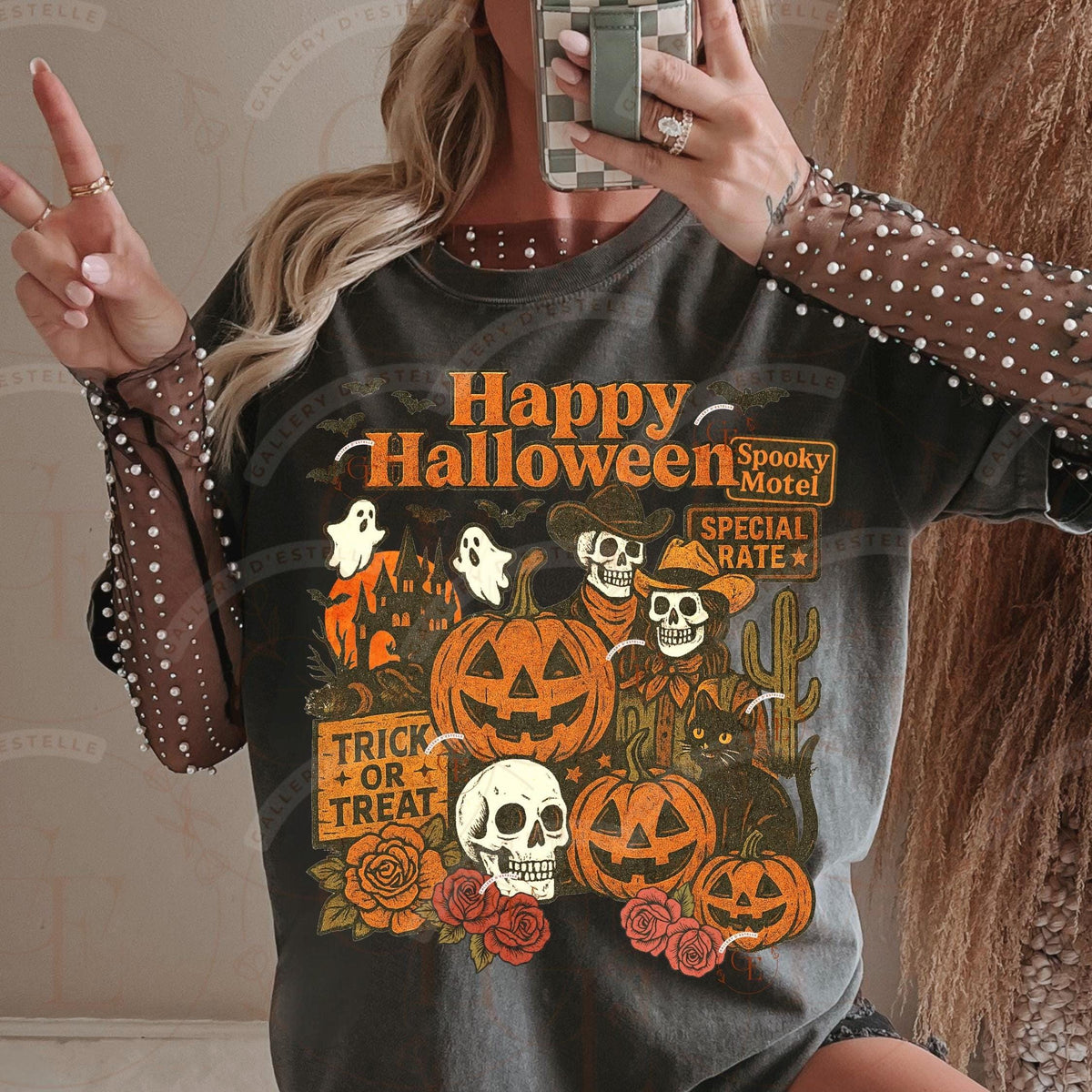 Person wearing a Halloween-themed t-shirt with pumpkins, ghosts, and skulls.