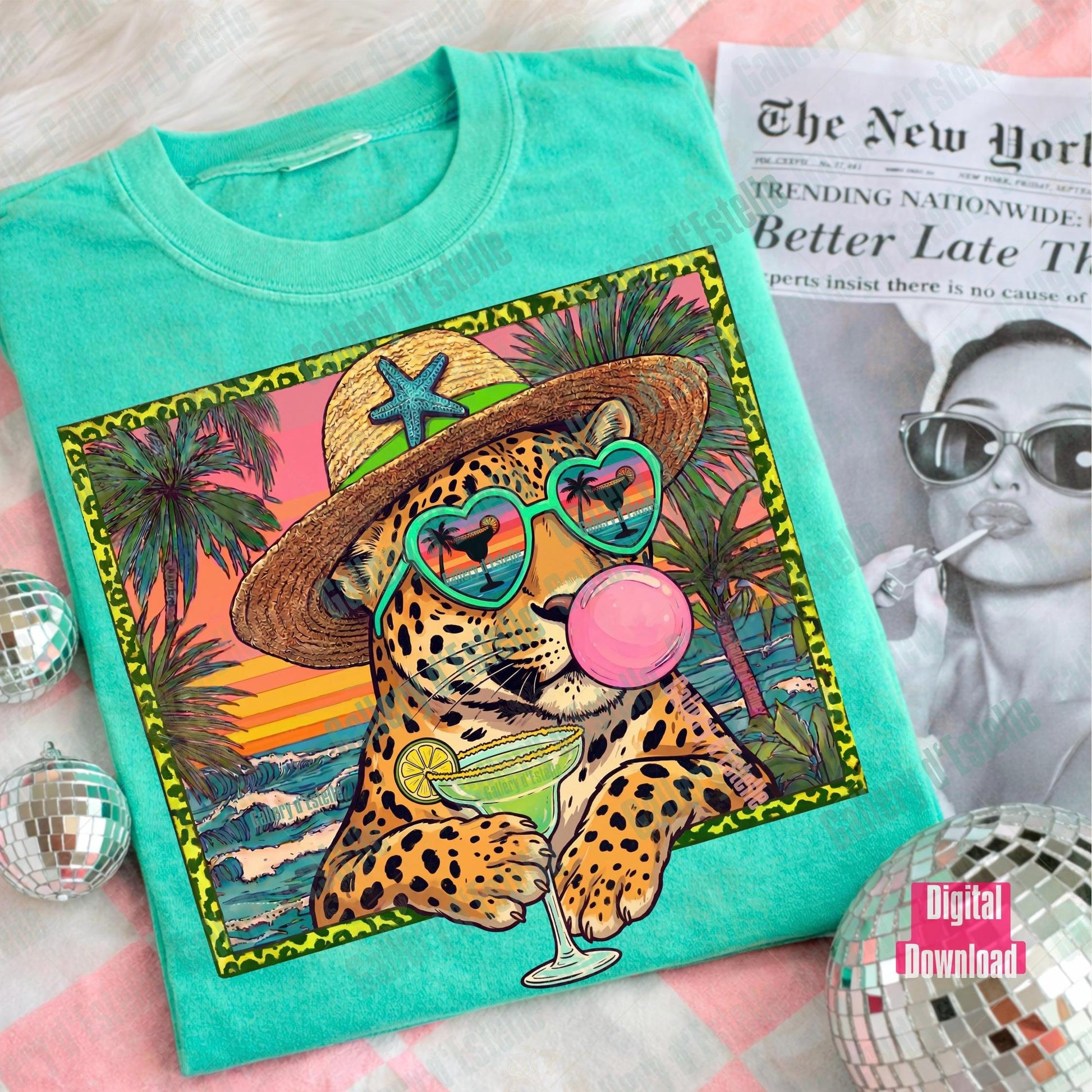 Turquoise t-shirt with a colorful leopard graphic design featuring sunglasses and a hat, placed on a surface with a magazine underneath.