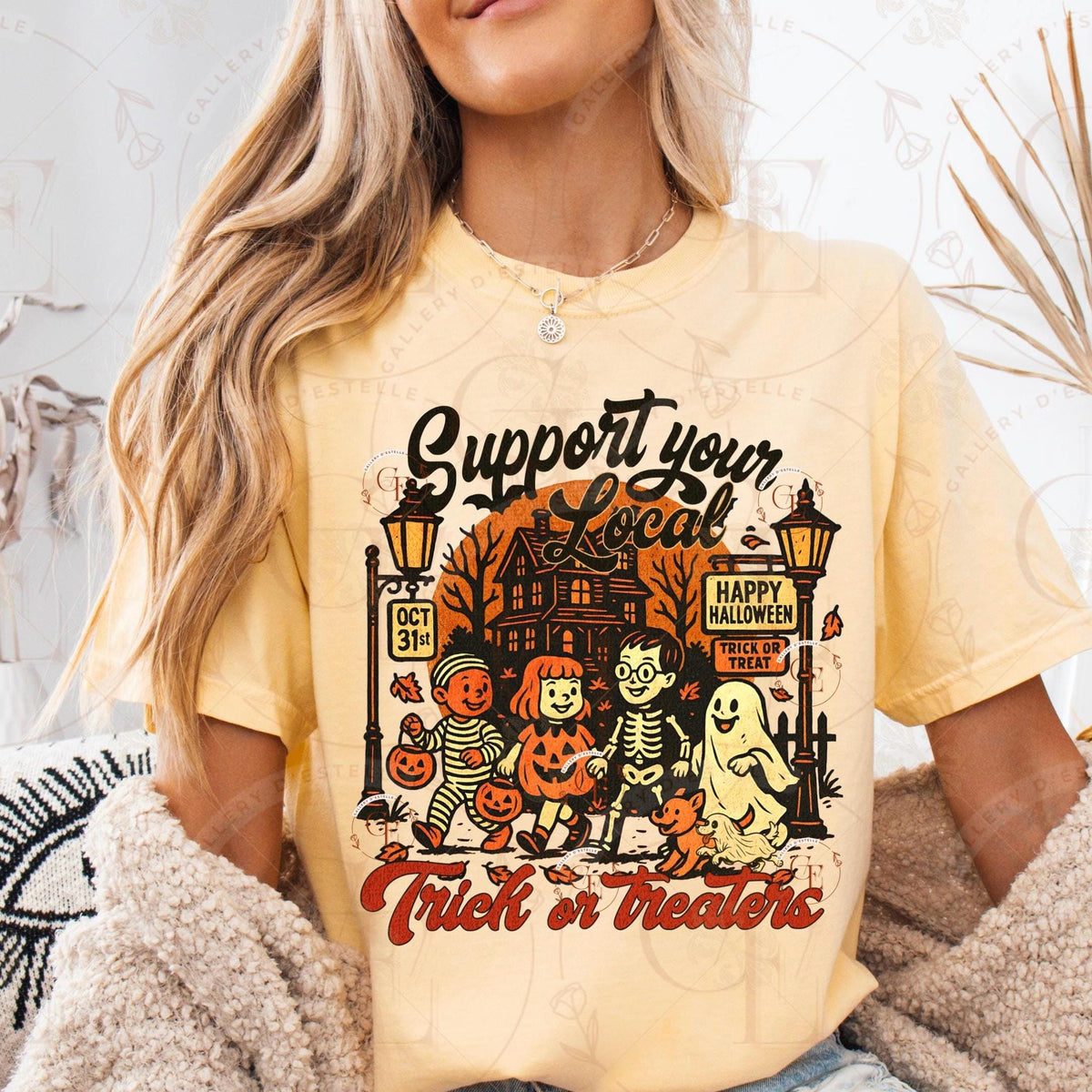 Person wearing a yellow t-shirt with Halloween-themed design and text.