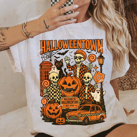 Person wearing a white t-shirt with 'Halloweentown' graphic design featuring skeletons, pumpkins, and a taxi.