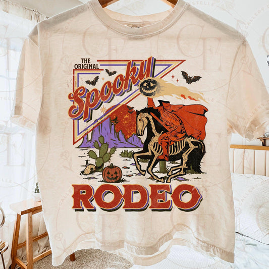T-shirt with a Halloween-themed design featuring a skeleton rider on a horse, text 'The Original Spooky Rodeo', and festive elements.