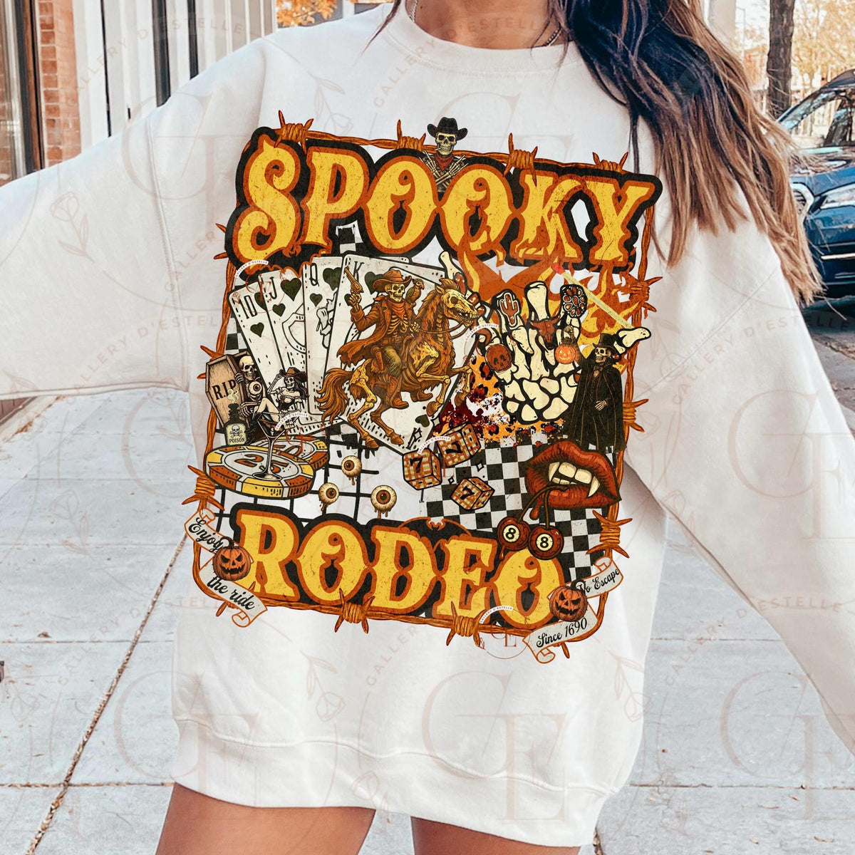 Person wearing a white sweatshirt with 'Spooky Rodeo' graphic design outdoors.