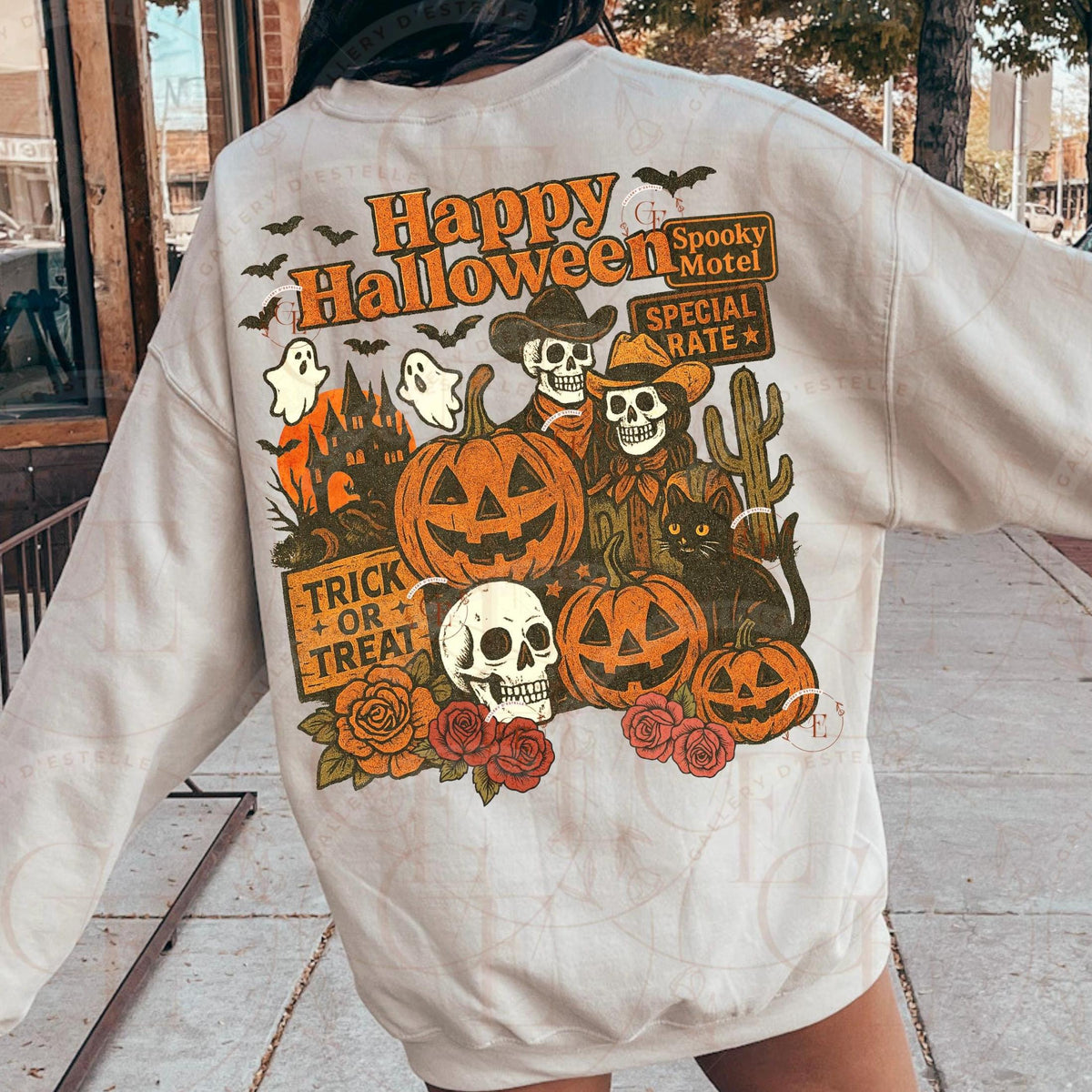 Person wearing a Halloween-themed sweatshirt with pumpkins, ghosts, and skeletons.