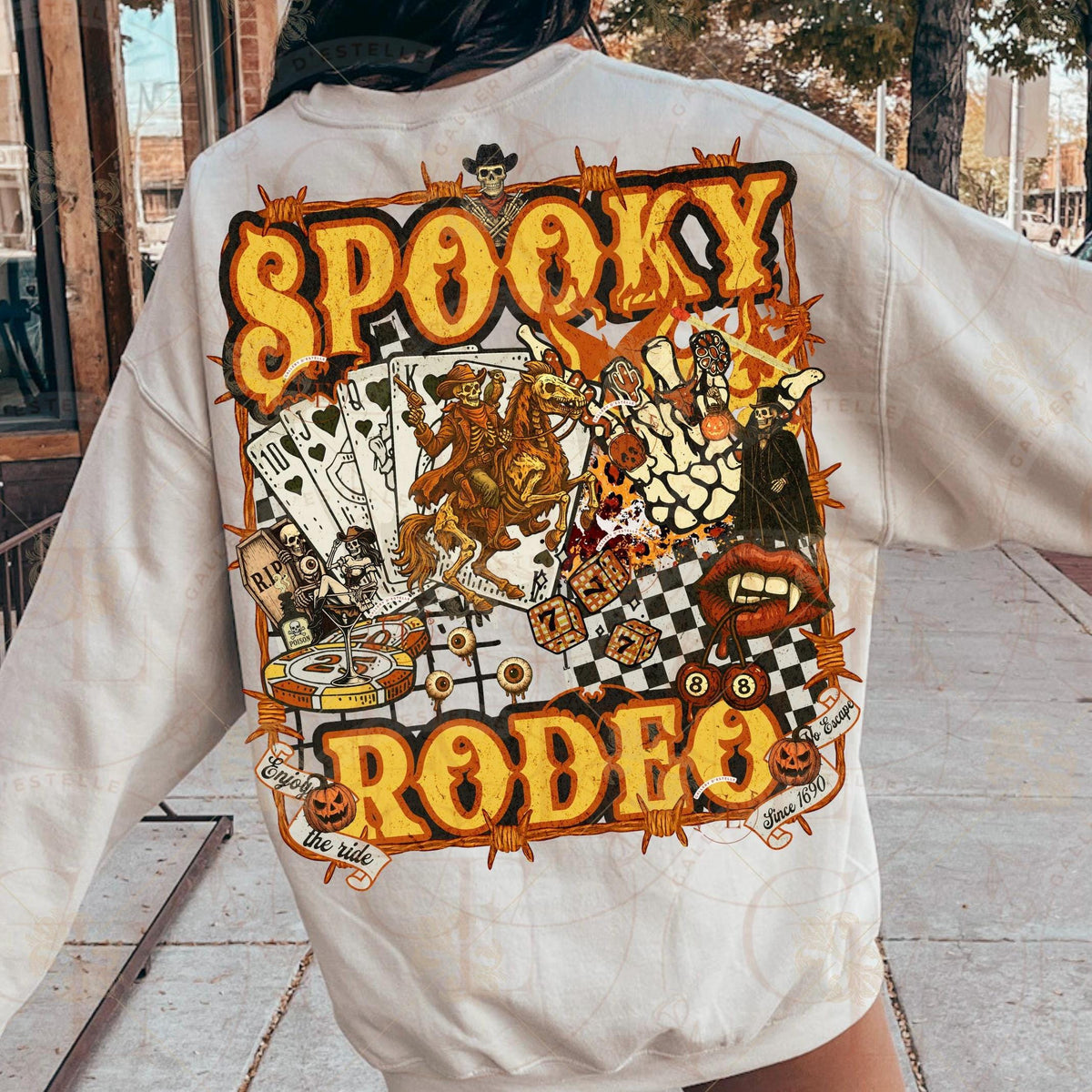 Person wearing a white sweatshirt with 'Spooky Rodeo' graphic design.